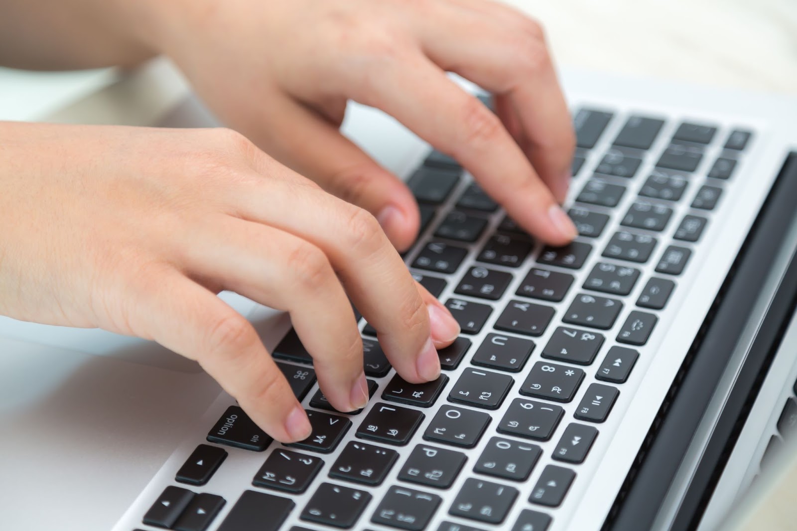 Close up of hands next to a keyboard