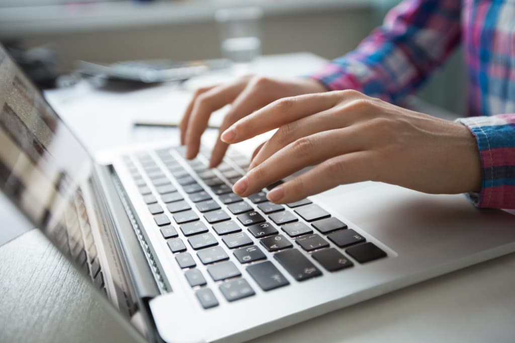 Hands Typing on Laptop