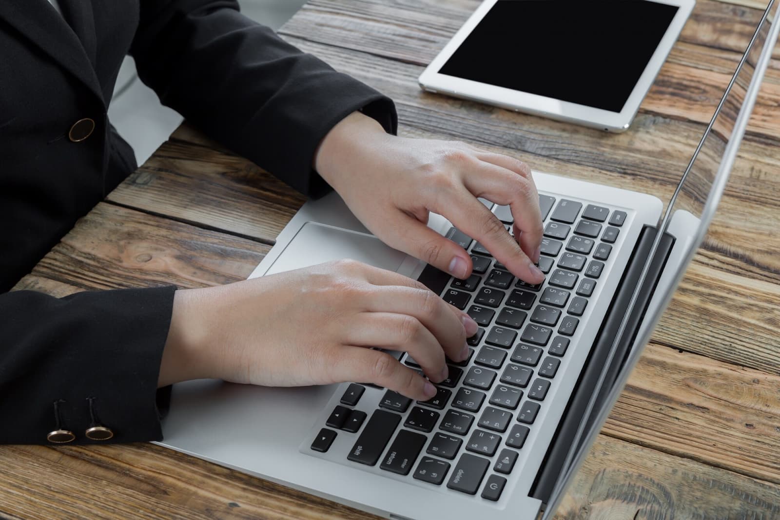 Man's hands typing on a laptop