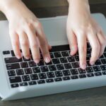 Top view of person writing on a laptop