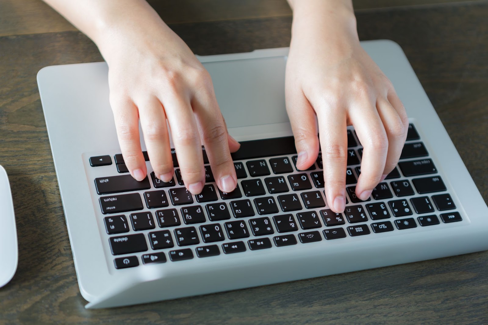 Top view of person writing on a laptop